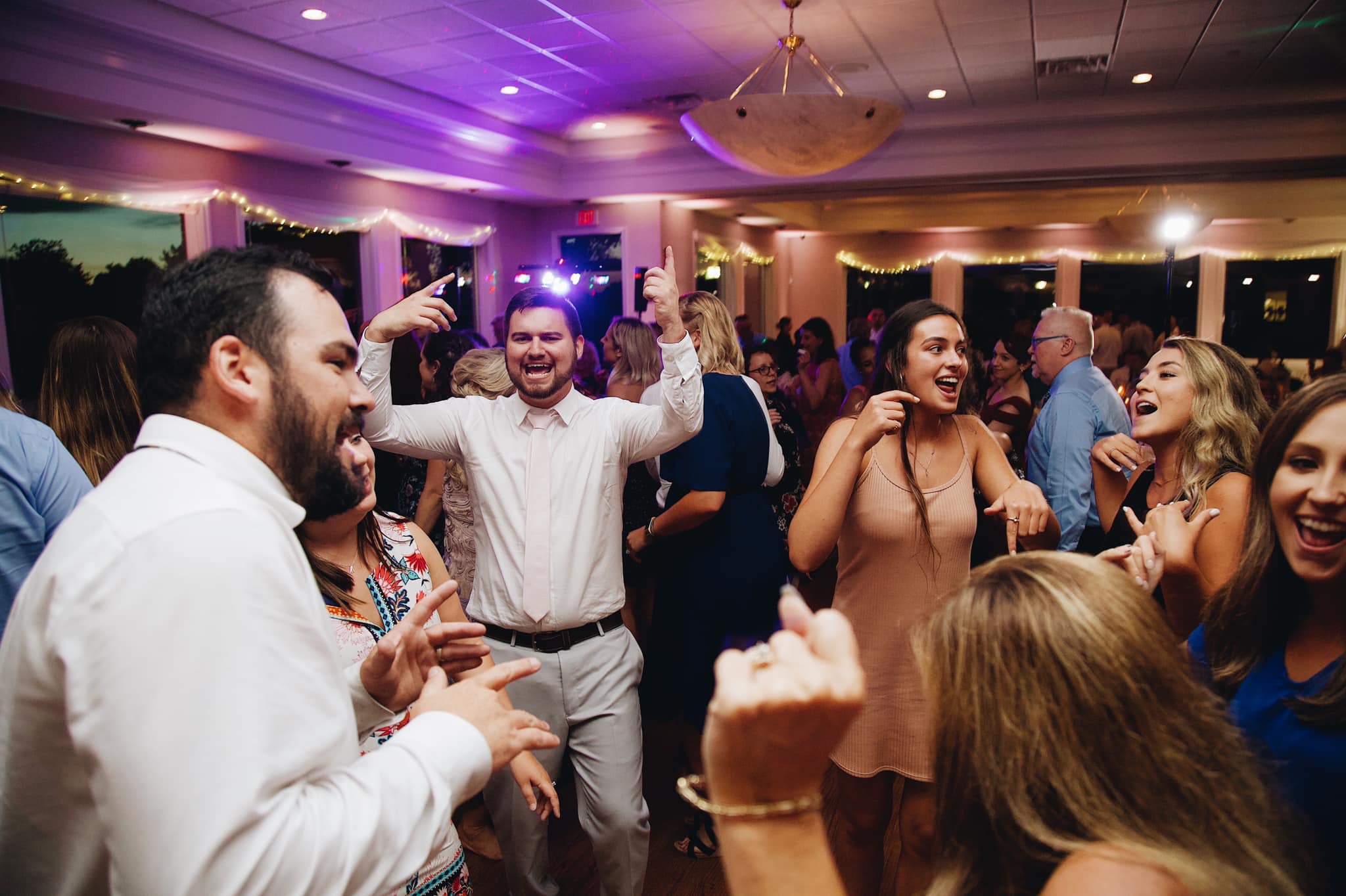 A group of people dancing in the middle of a room.