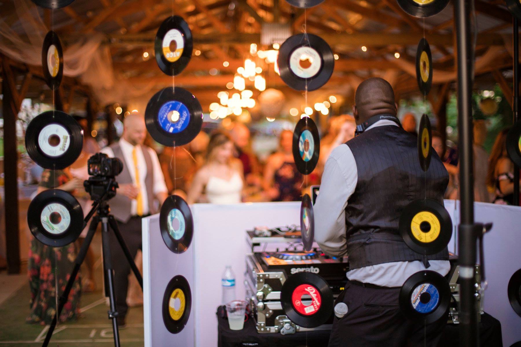 A man standing in front of a table with records hanging from it.