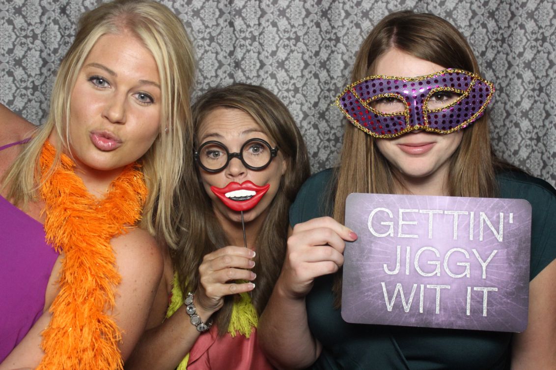 Three women posing for a photo booth picture.