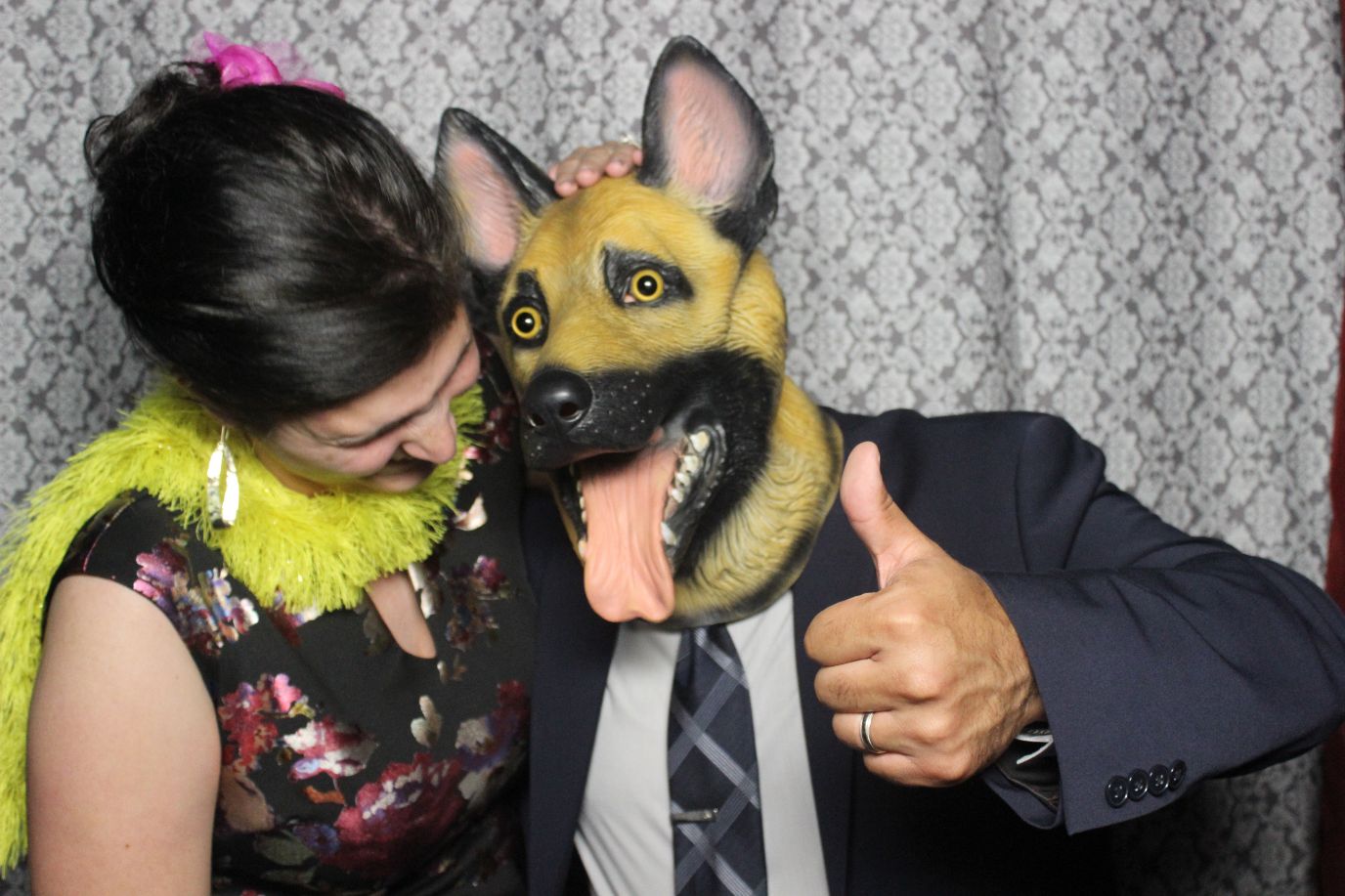 A man and woman wearing dog masks in a photo booth.