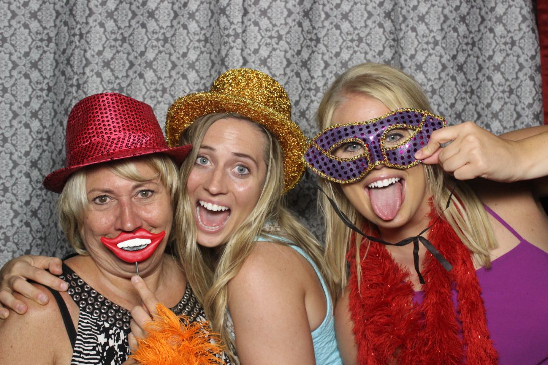 Three women posing for a photo booth picture.